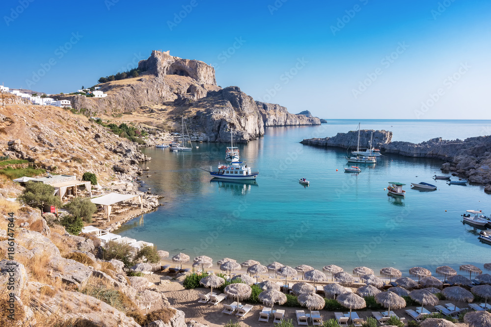 St. Paul´s bay with boats, Lindos acropolis in background (Rhodes, Greece)