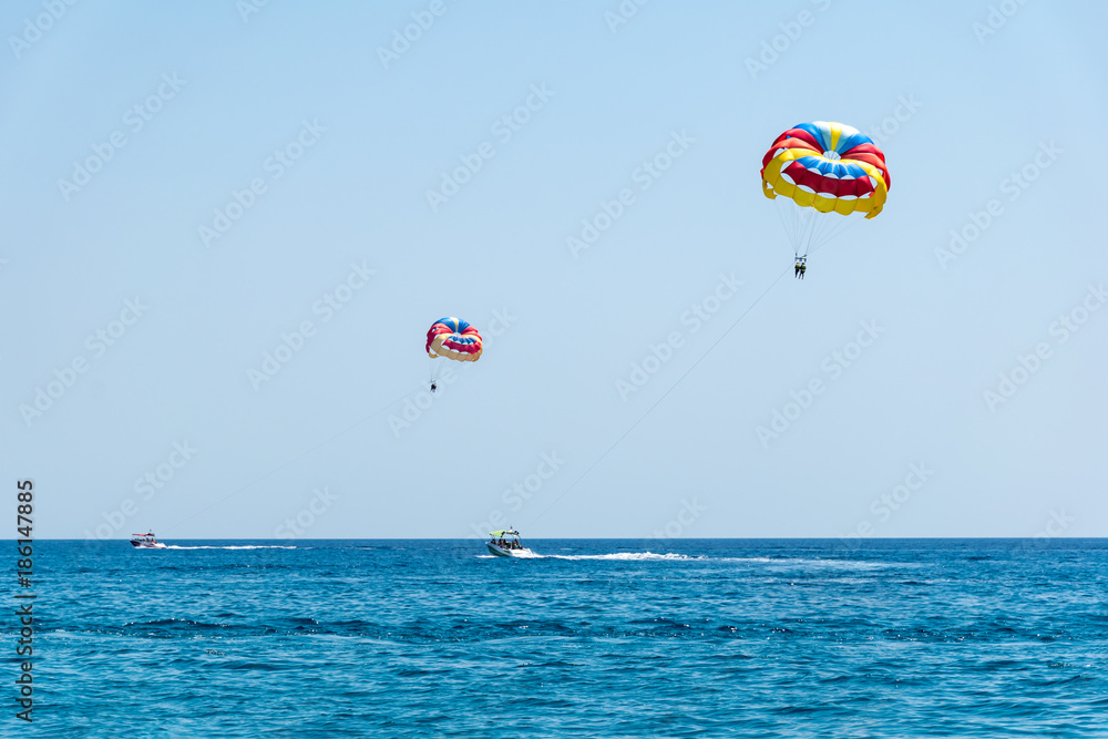 Two speed boats with people flying on parasailing parachute (RHODES, GREECE) Two speed boats with people flying on parasailing parachute (RHODES, GREECE)