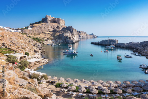 St. Paul´s bay with boats, Lindos acropolis in background (Rhodes, Greece)