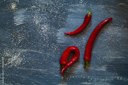red chili pepper on a dark blue background with saltwater, salt, top view, natural light, free space for text