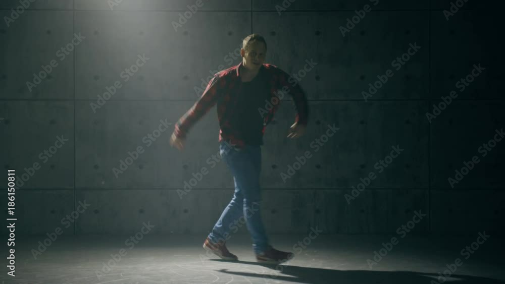 Young male breakdancer dancing in studio Young male breakdancer dancing in studio