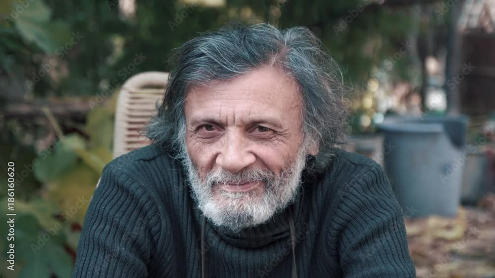 A gray-haired grandfather looking at the camera and winks A gray-haired grandfather looking at the camera and winks