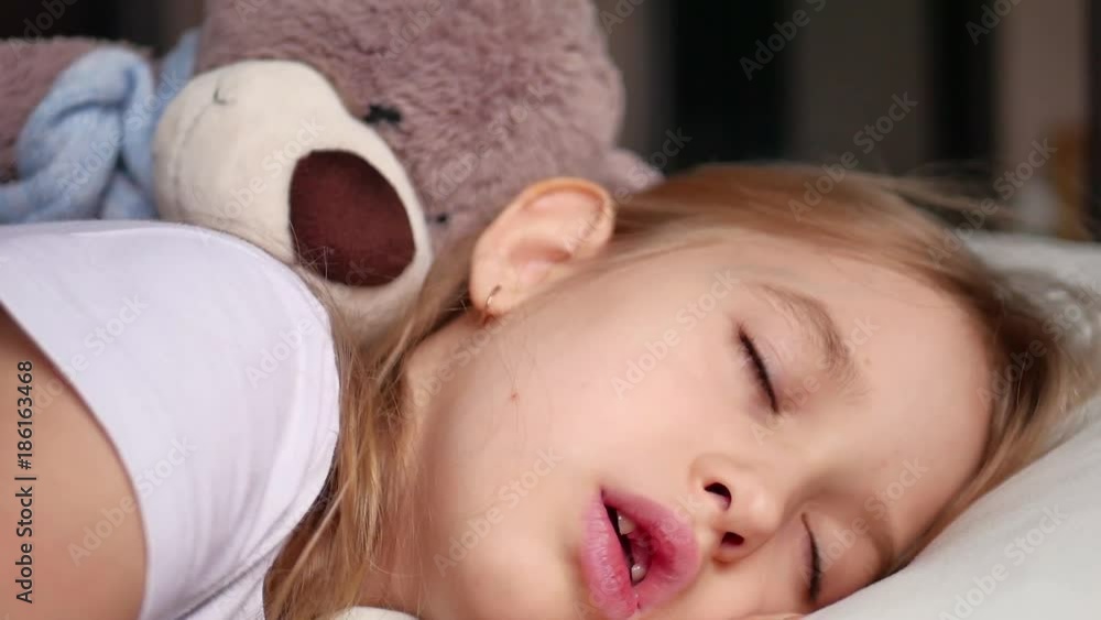 Cute little girl sleeping with teddy bear in bed Cute little girl sleeping with teddy bear in bed