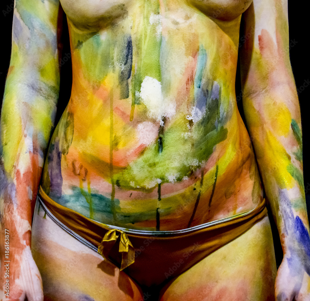 Fototapeta premium Body art. Drawing on the body. Beautiful girl with painted body watercolors. A white young girl painted the body with paint.