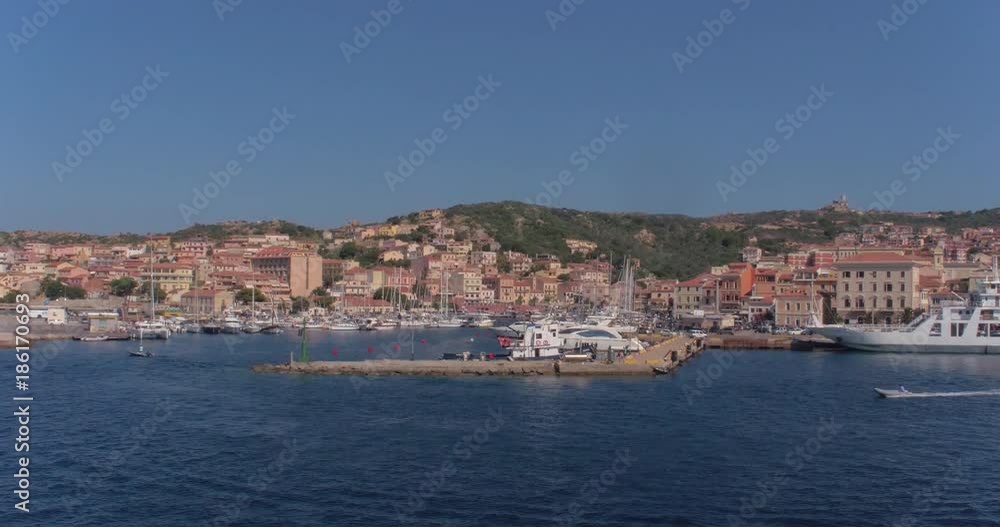 SARDINIA, ITALY – JULY 2016 : Aerial shot of Isola Maddalena harbour on a sunny day with boats and cityscape in view SARDINIA, ITALY – JULY 2016 : Aerial shot of Isola Maddalena harbour on a sunny day with boats and cityscape in view
