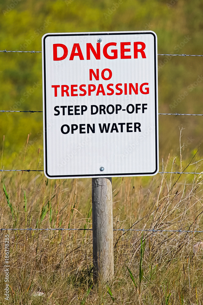 Danger no trespassing steep drop-off open water sign Danger no trespassing steep drop-off open water sign