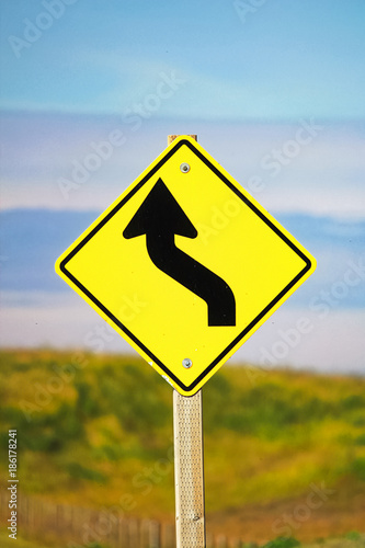 Closeup of a curvy road ahead sign