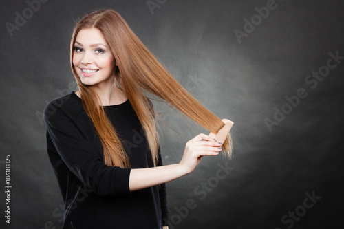 Long haired girl combing her beauty hair. photo