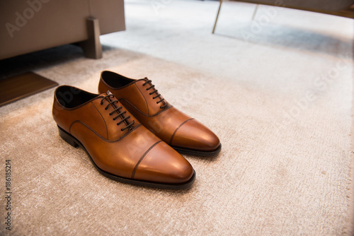 Brown leather classic male shoes on the floor in interior