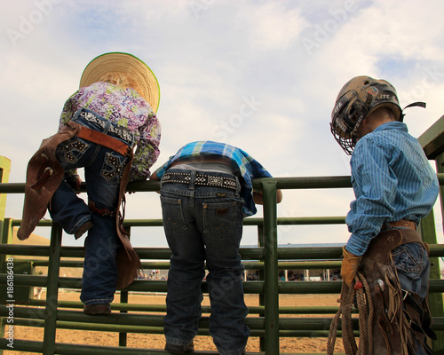 Little Cowboys and Cowgirl Climbing Fence