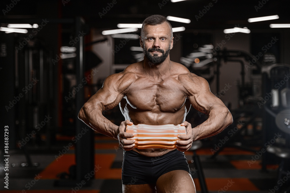 Fototapeta premium Old brutal strong bodybuilder athletic men pumping up muscles with dumbbells