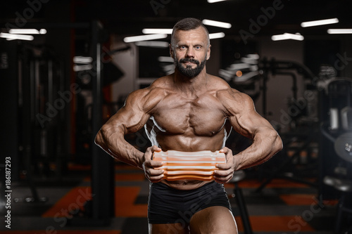 Old brutal strong bodybuilder athletic men pumping up muscles with dumbbells