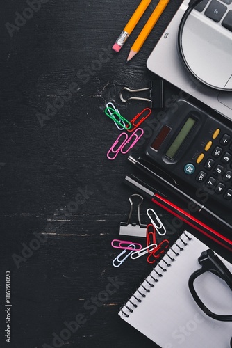 Office desktop, Laptop, notebook, pen. On a black background. Top view. Free space for text. Copy space.