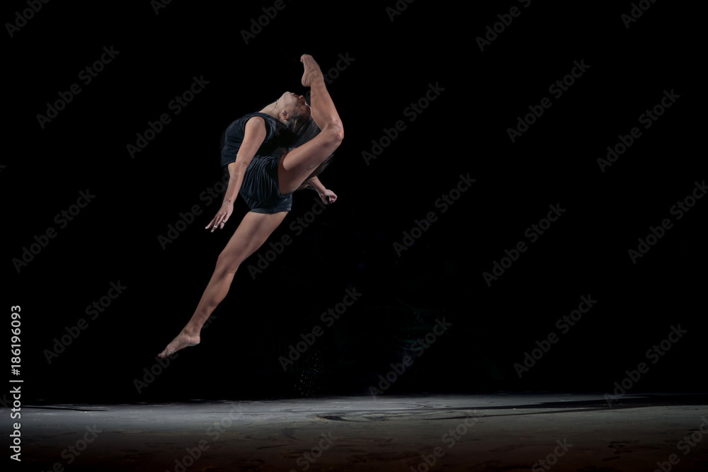 Girl gymnast in a jump with a twine