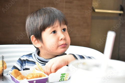 The boy with a startled expression sitting at the table