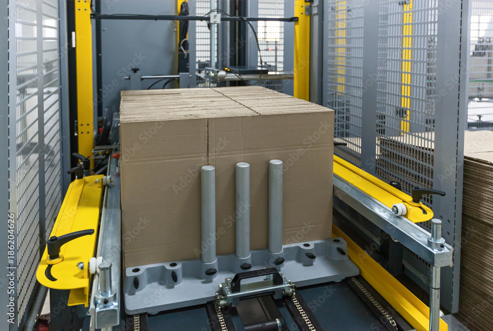 Strapping Machine for Industrail Packaging Line, Modern machine for packaging line in factory, Industrial and technology concept. Strapping Machine for Industrail Packaging Line, Modern machine for packaging line in factory, Industrial and technology concept.