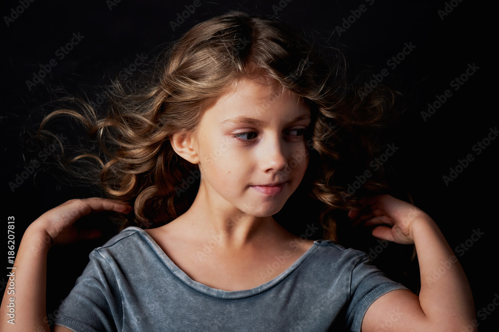 kinky girl with long hair. In the Studio on a black background. A fairy tale for children. Lives in the frame kinky girl with long hair. In the Studio on a black background. A fairy tale for children. Lives in the frame