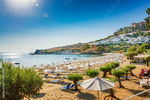 View of sandy beach in Bay of Lindos, Acropolis in background (Rhodes, Greece)