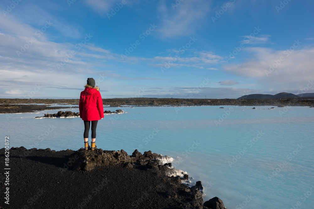 Woman standing near a blue lagoon in Iceland 