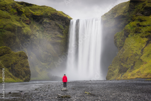 Woman standing near Skogafoss Waterfall in Iceland 