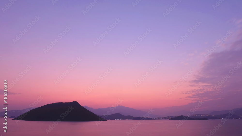 small island, mountain and sea at sunset