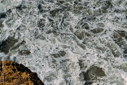 Sea water surface with white foam and waves pattern