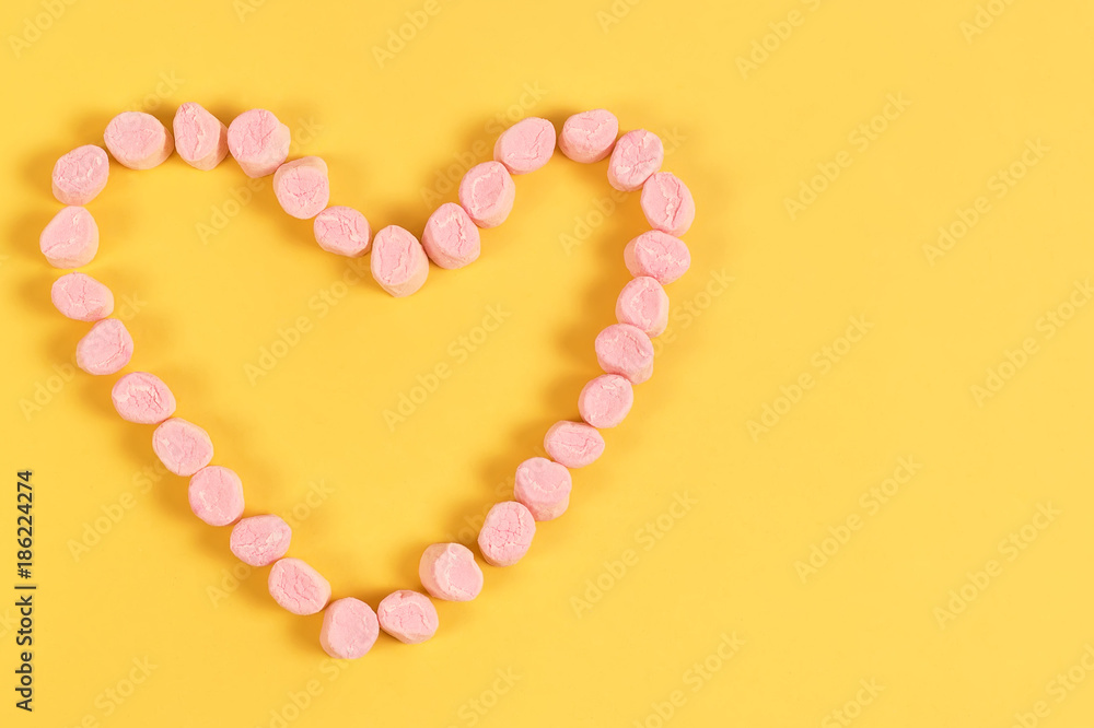marshmallow sweets placed in heart shape.valentine's day and love concept on yellow background marshmallow sweets placed in heart shape.valentine's day and love concept on yellow background