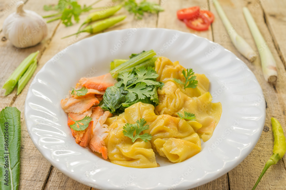 dumpling and roasted red pork with vegetable and spice on table wood background