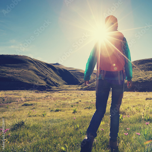 backpacking female hiking in sunrise mountains