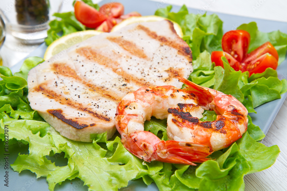 plate of grilled fish with salad and cherry tomatoes plate of grilled fish with salad and cherry tomatoes