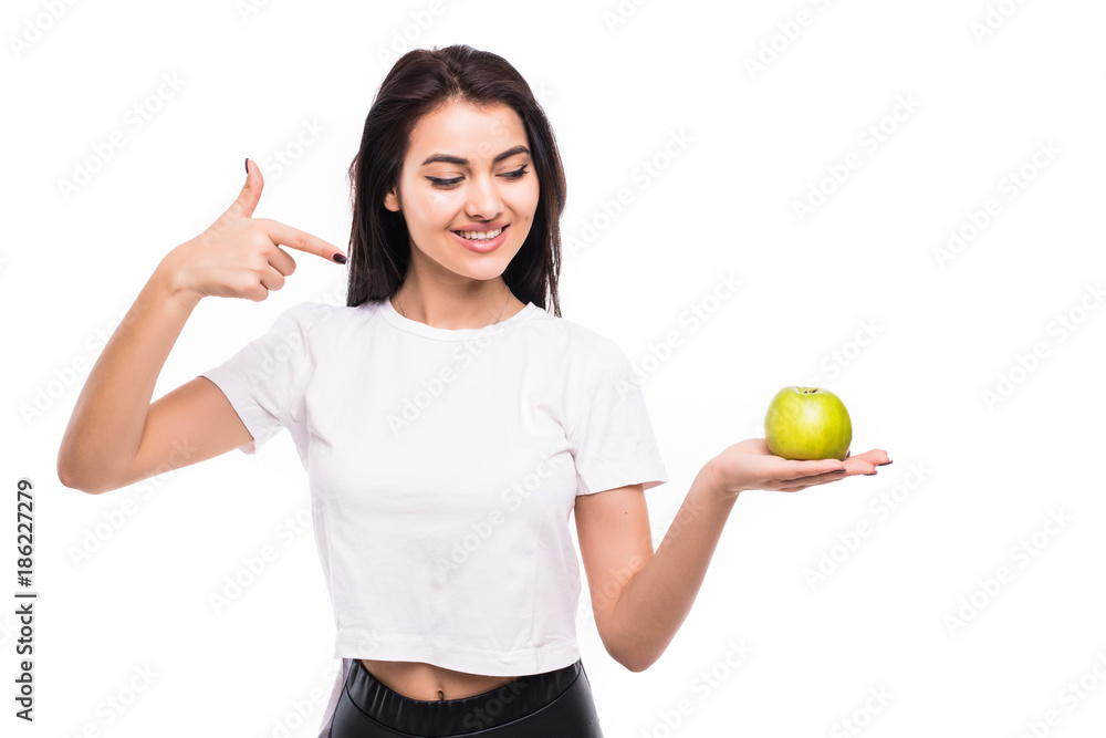 Portrait of a smiling pretty girl holding an apple and pointing finger over white background Portrait of a smiling pretty girl holding an apple and pointing finger over white background