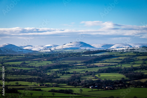 Snow covered mountains of Caer Caradoc and the Long Mynd that overlook Church Stretton from Wenlock Edge region, UK
