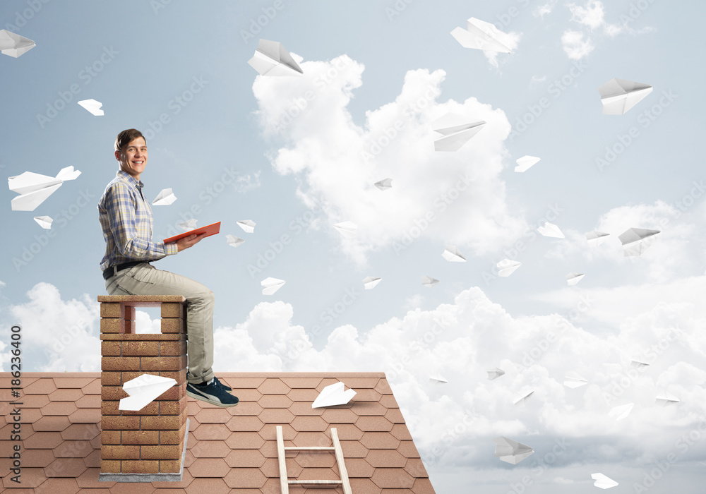 Handsome student guy reading book and paper planes flying in air Handsome student guy reading book and paper planes flying in air