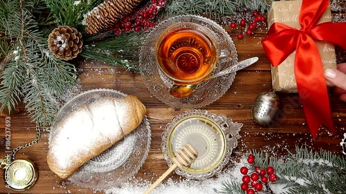 winter tea A cup of tea with honey and croissant or cookies, a branch of a Christmas tree in the snow, Christmas lights