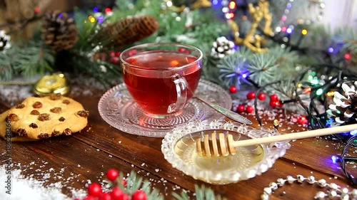 winter tea A cup of tea with honey and croissant or cookies, a branch of a Christmas tree in the snow, Christmas lights