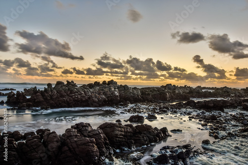 Stunning evening shot of rocks and breaking waves at Cape Agulhas, South Africa's and therefore Africa's southernmost point. Beautiful rocks and wild ocean in the background.