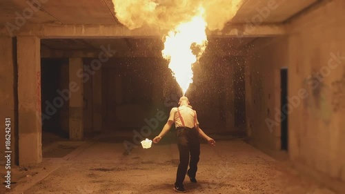 Fire show artist breathe fire in the dark, slow motion photo