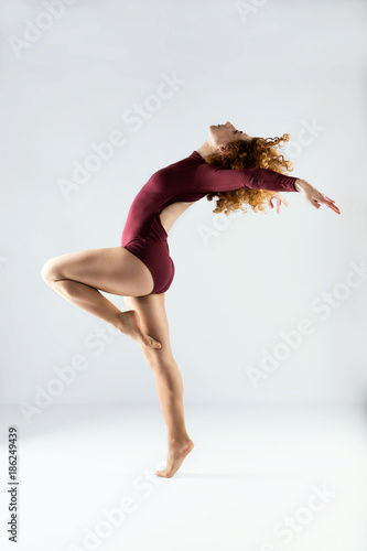 Beautiful young professional dancer dancing over white background.