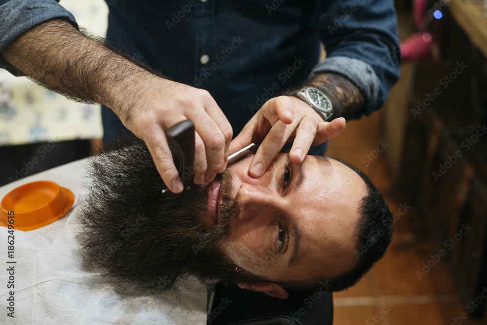 Bearded Man Getting Beard Haircut With A Razor By Barber