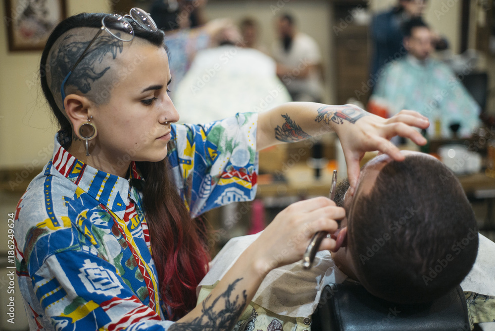 Obraz premium Woman Getting Beard Haircut With A Razor By Barber