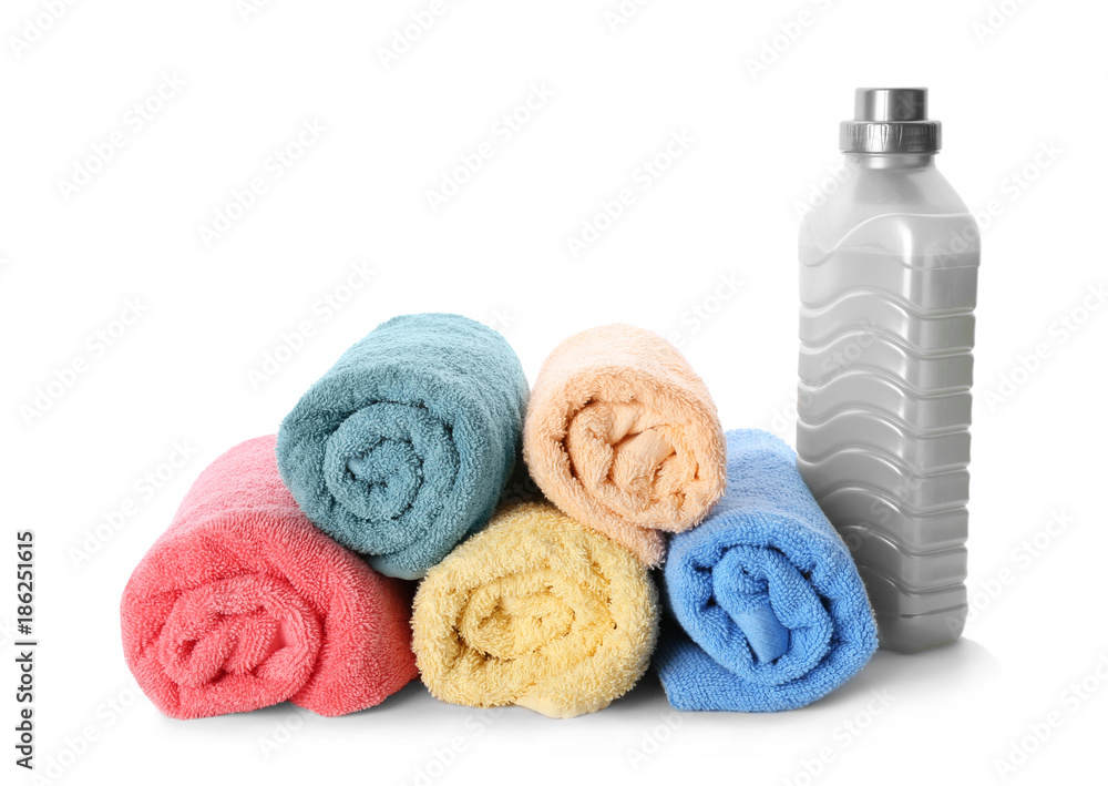 Folded towels and laundry detergent on white background Folded towels and laundry detergent on white background