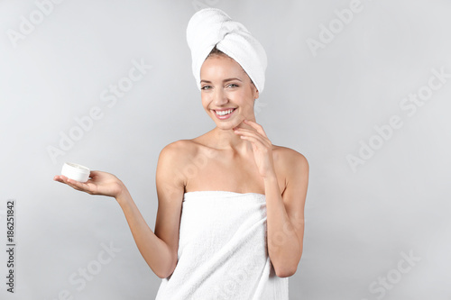 Young woman with body cream...