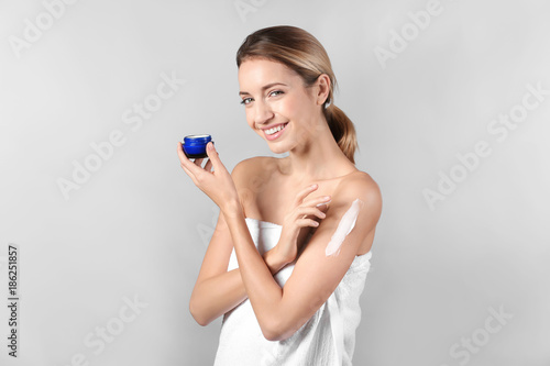 Young woman applying body c...