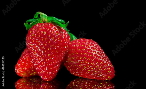 Wallpaper Mural Red Strawberries with green leafs, on top of a reflective glass surface, and black background, isolated. Torontodigital.ca