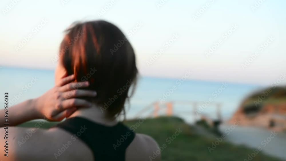 Close up shot othe female sportsman walking at the beach in sunset lights Close up shot othe female sportsman walking at the beach in sunset lights