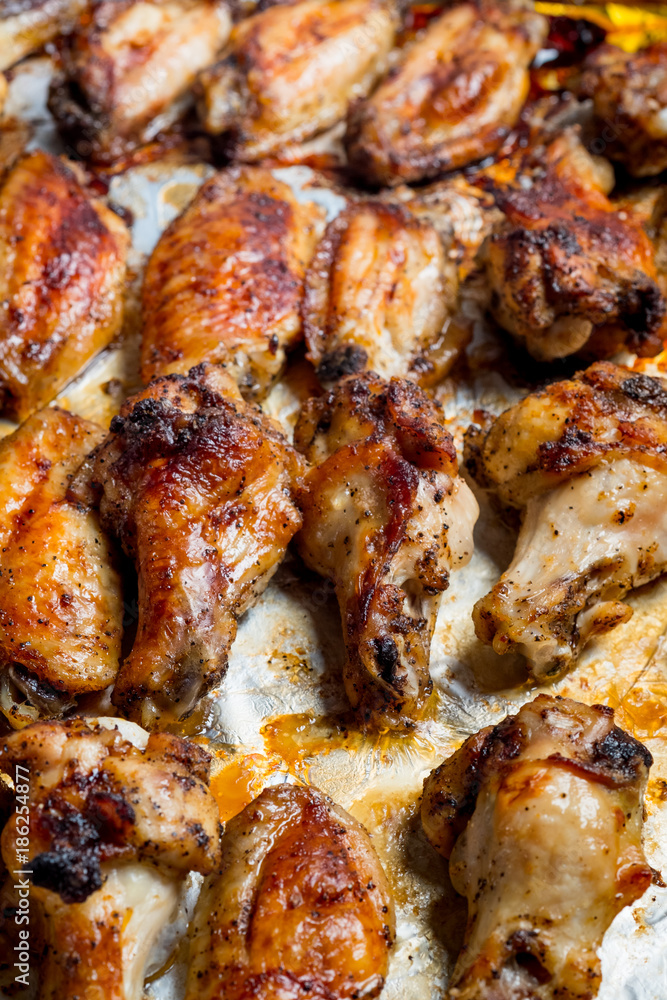 Chicken wings baked in a pan on white background isolated. Top flat, from above. Chicken wings baked in a pan on white background isolated. Top flat, from above.