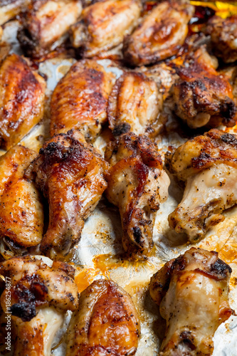 Chicken wings baked in a pan on white background isolated. Top flat, from above.