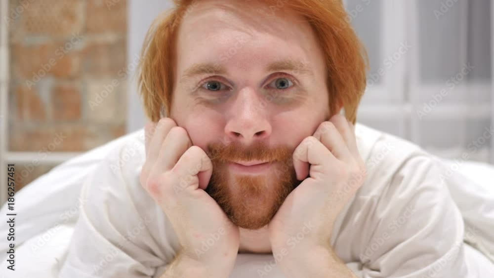 Victory Sign by Young Redhead Beard Man, Positive gesture in Bed Victory Sign by Young Redhead Beard Man, Positive gesture in Bed