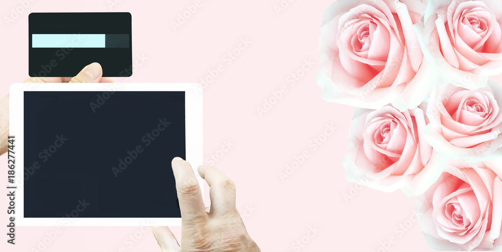 Obraz premium Valentine season sale shopping by tablet with credit card online internet connection for lover on beautiful group of pink roses background.
