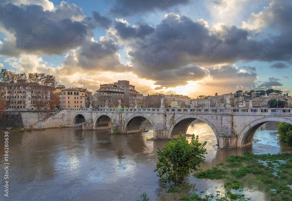 Rome (Italy) - The Tiber river and the monumental Lungotevere with 'Ponte Sant'Angelo' bridge with statues of angels